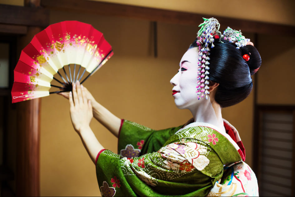 Imagen de la cara de una mujer con el traje y maquillaje tradicional de una geisha