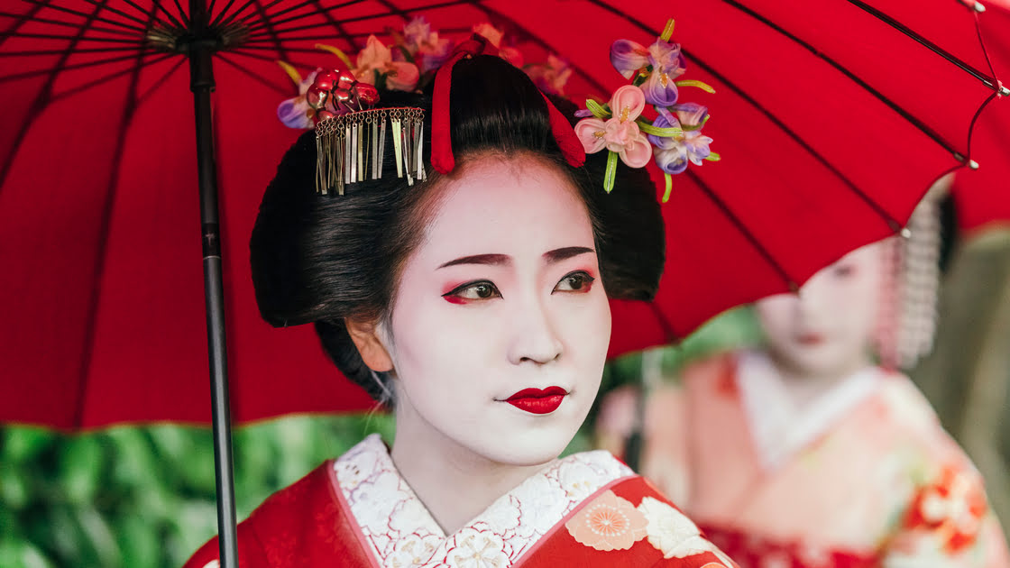 Image of a woman's face in the traditional costume and makeup of a geisha