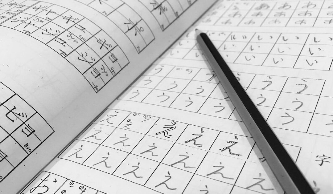book with Japanese alphabet drawing and a pencil on top